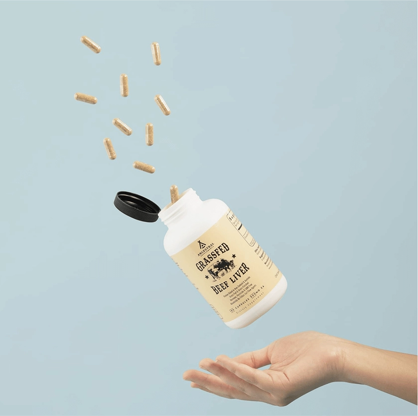 Capsules pouring from a bottle into an open hand